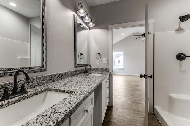 bathroom with a ceiling fan, walk in shower, a sink, and wood finished floors