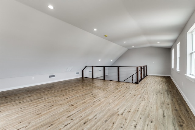 bonus room with lofted ceiling, baseboards, visible vents, and wood finished floors