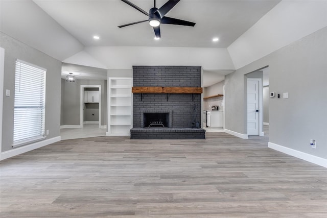 unfurnished living room featuring lofted ceiling, ceiling fan, built in shelves, baseboards, and a brick fireplace