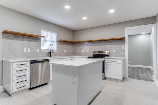 kitchen with open shelves, appliances with stainless steel finishes, a sink, and white cabinetry