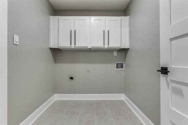 laundry area with cabinet space, baseboards, tile patterned floors, hookup for a washing machine, and electric dryer hookup