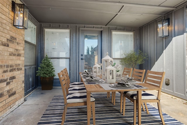 dining area with concrete flooring and brick wall