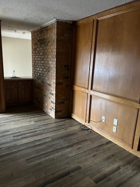 unfurnished room featuring dark wood-style flooring and a textured ceiling