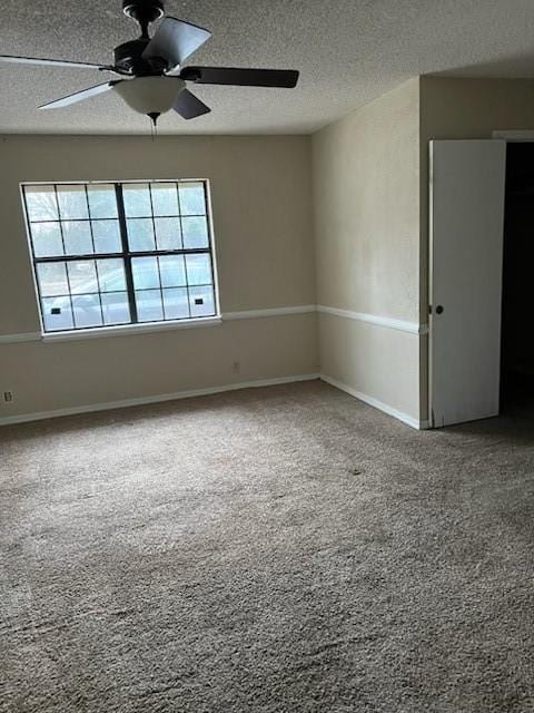 carpeted spare room featuring ceiling fan, baseboards, and a textured ceiling