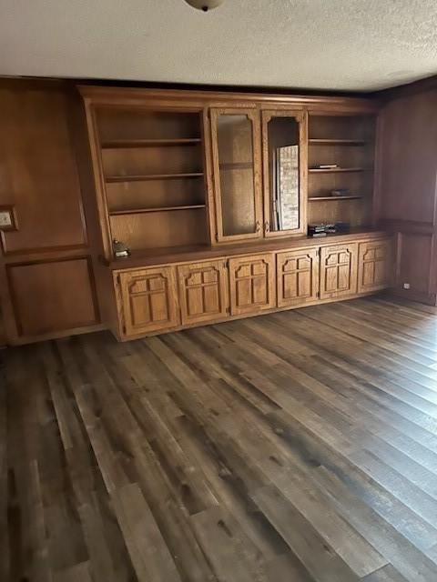 details with built in shelves, a textured ceiling, and wood finished floors