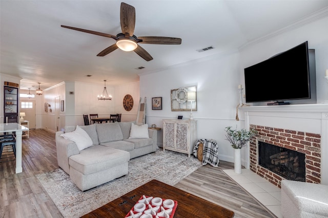 living room featuring ornamental molding, visible vents, and wood finished floors