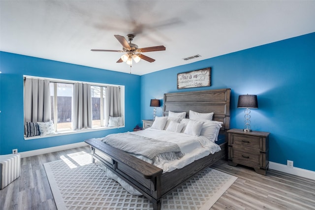 bedroom featuring baseboards, visible vents, ceiling fan, and wood finished floors