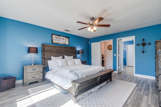 bedroom featuring visible vents, baseboards, ceiling fan, and wood finished floors