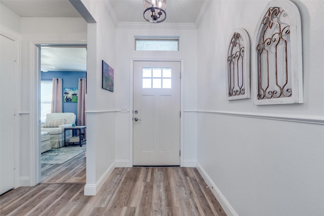 entrance foyer with crown molding, baseboards, a wealth of natural light, and wood finished floors