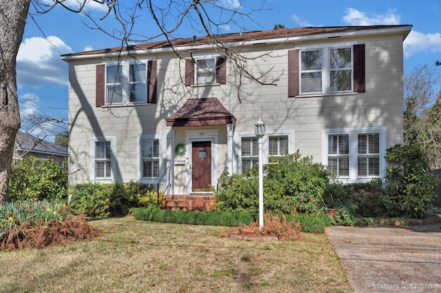 colonial home featuring a front lawn