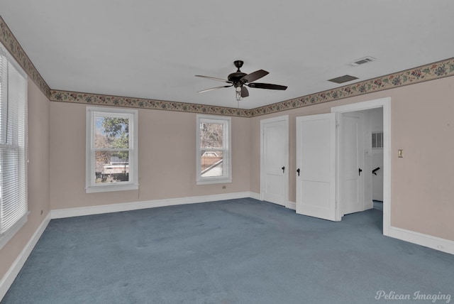 unfurnished bedroom featuring ceiling fan, baseboards, visible vents, and dark colored carpet