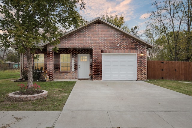 ranch-style home with a garage, brick siding, driveway, and fence