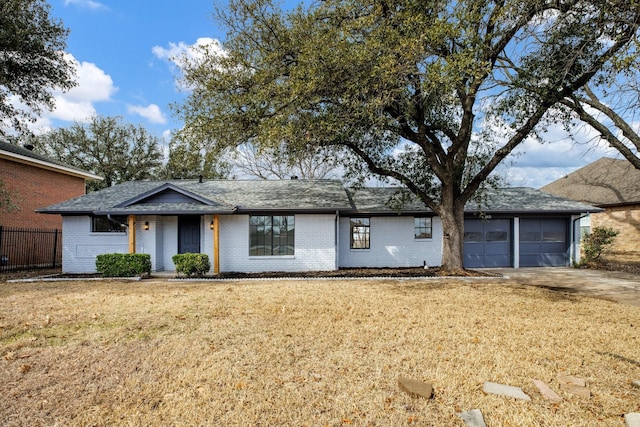 ranch-style house with a garage, a front yard, brick siding, and driveway