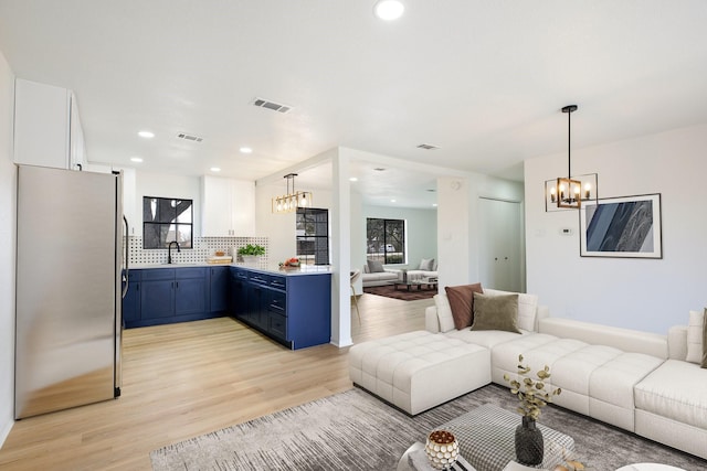 interior space with an inviting chandelier, visible vents, light wood finished floors, and recessed lighting