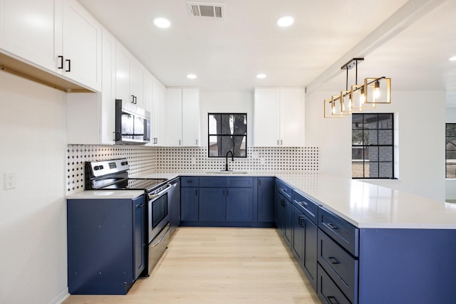 kitchen with stainless steel appliances, a peninsula, visible vents, and blue cabinets