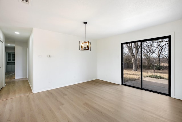 unfurnished dining area with light wood-type flooring, baseboards, and an inviting chandelier