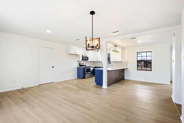 kitchen featuring visible vents, open floor plan, a peninsula, an inviting chandelier, and stainless steel appliances