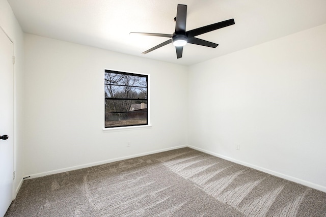 carpeted empty room with a ceiling fan and baseboards