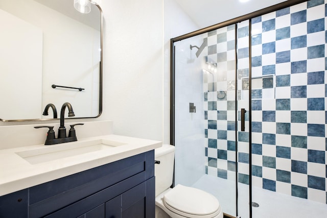 full bathroom featuring a shower stall, toilet, and vanity