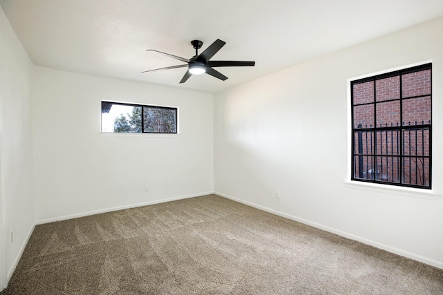 spare room featuring carpet, ceiling fan, and baseboards