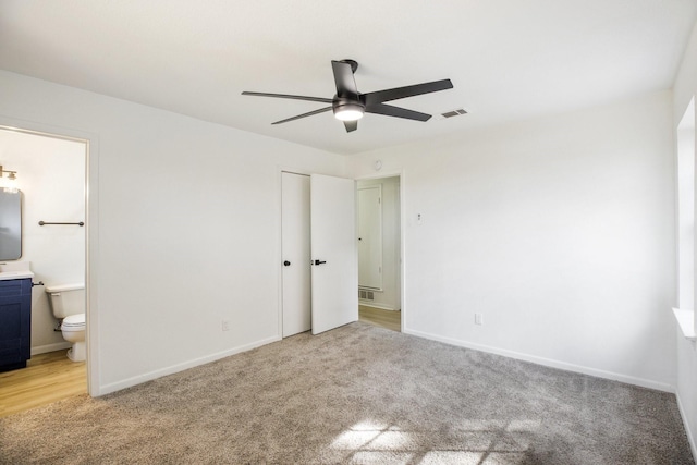 unfurnished bedroom featuring light carpet, baseboards, visible vents, and ensuite bathroom