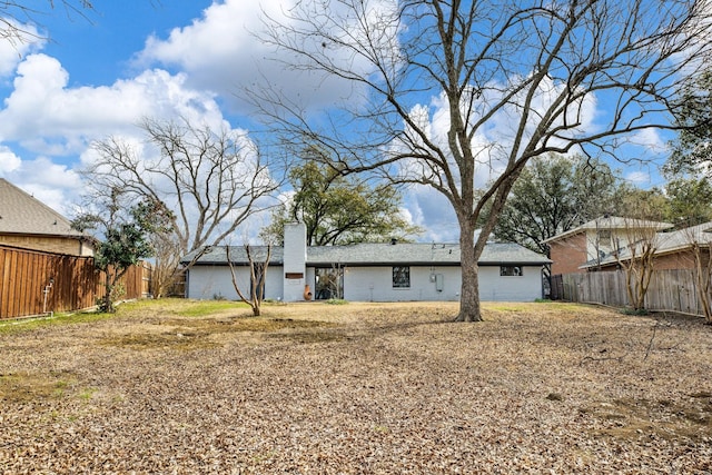 back of property with a chimney, fence, an attached carport, and brick siding