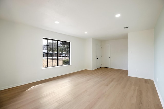 spare room with light wood finished floors, baseboards, visible vents, and recessed lighting