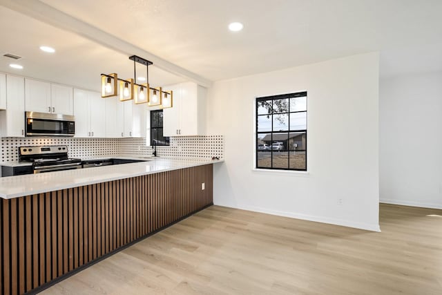 kitchen with appliances with stainless steel finishes, light wood-type flooring, visible vents, and decorative backsplash