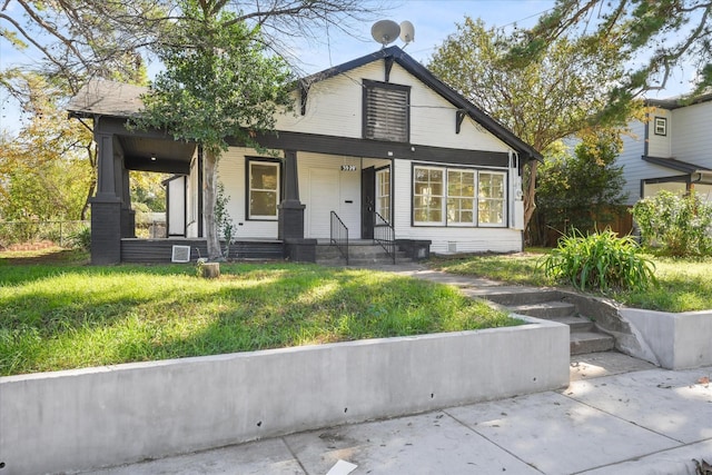 bungalow with a porch and a front lawn