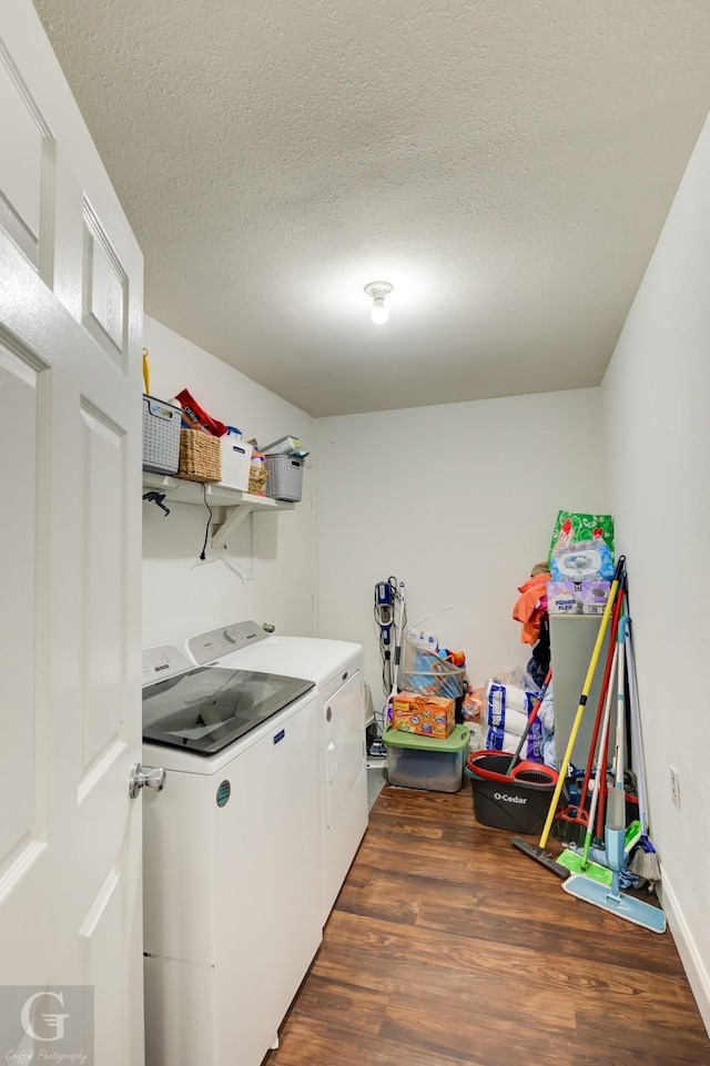 laundry room featuring a textured ceiling, laundry area, separate washer and dryer, and wood finished floors