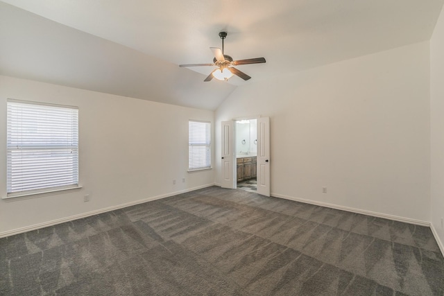 unfurnished room featuring a ceiling fan, vaulted ceiling, dark carpet, and baseboards