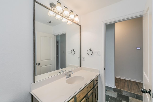 bathroom with baseboards, visible vents, and vanity