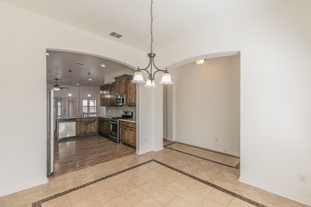 kitchen with stainless steel appliances, tasteful backsplash, visible vents, and baseboards