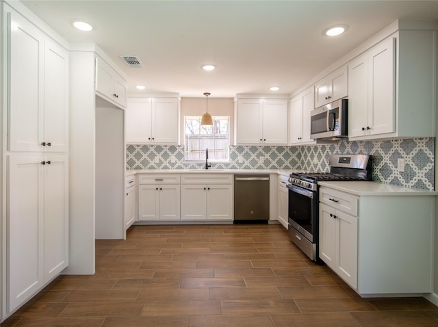 kitchen with visible vents, wood tiled floor, appliances with stainless steel finishes, and white cabinets