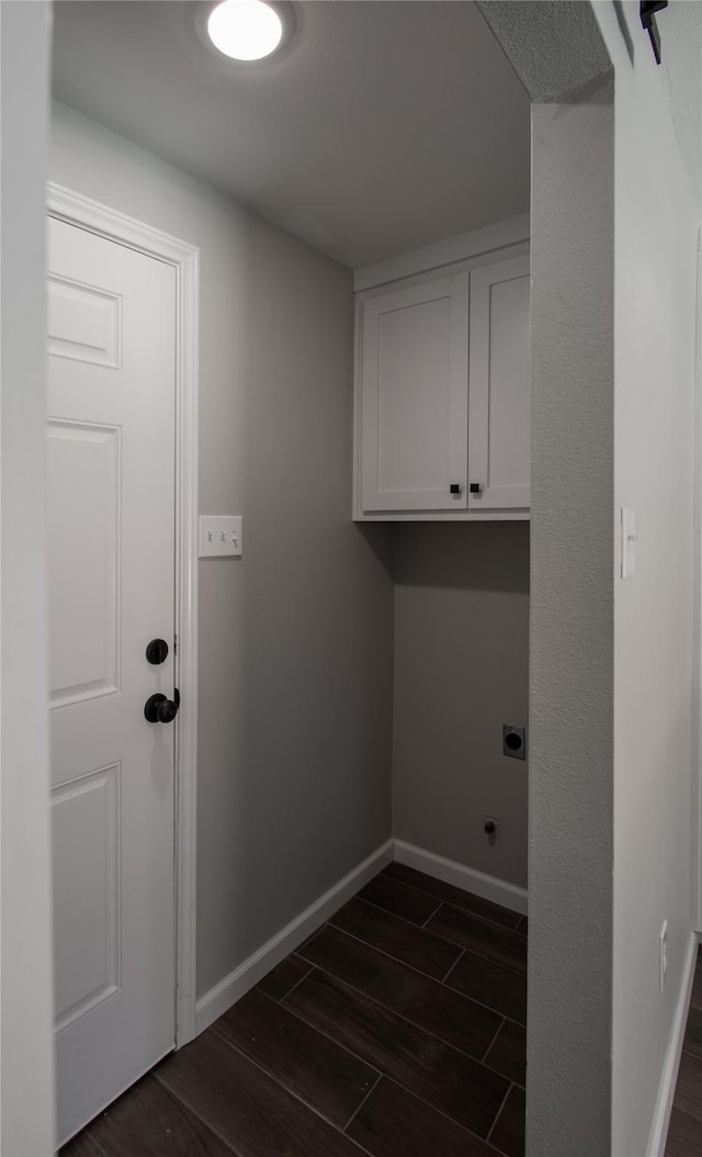 washroom with cabinet space, baseboards, dark wood-style floors, and hookup for an electric dryer