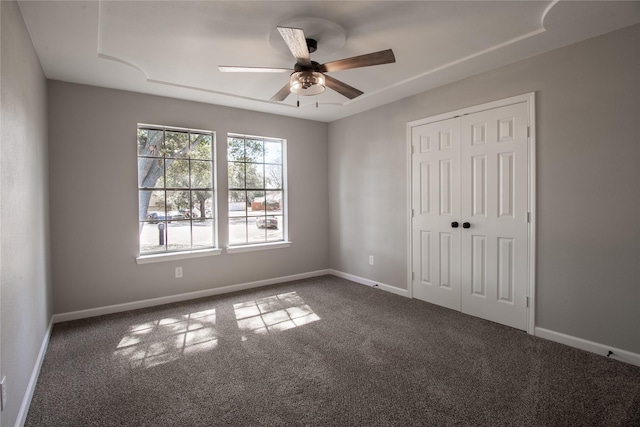 unfurnished bedroom with a ceiling fan, carpet, a closet, and baseboards