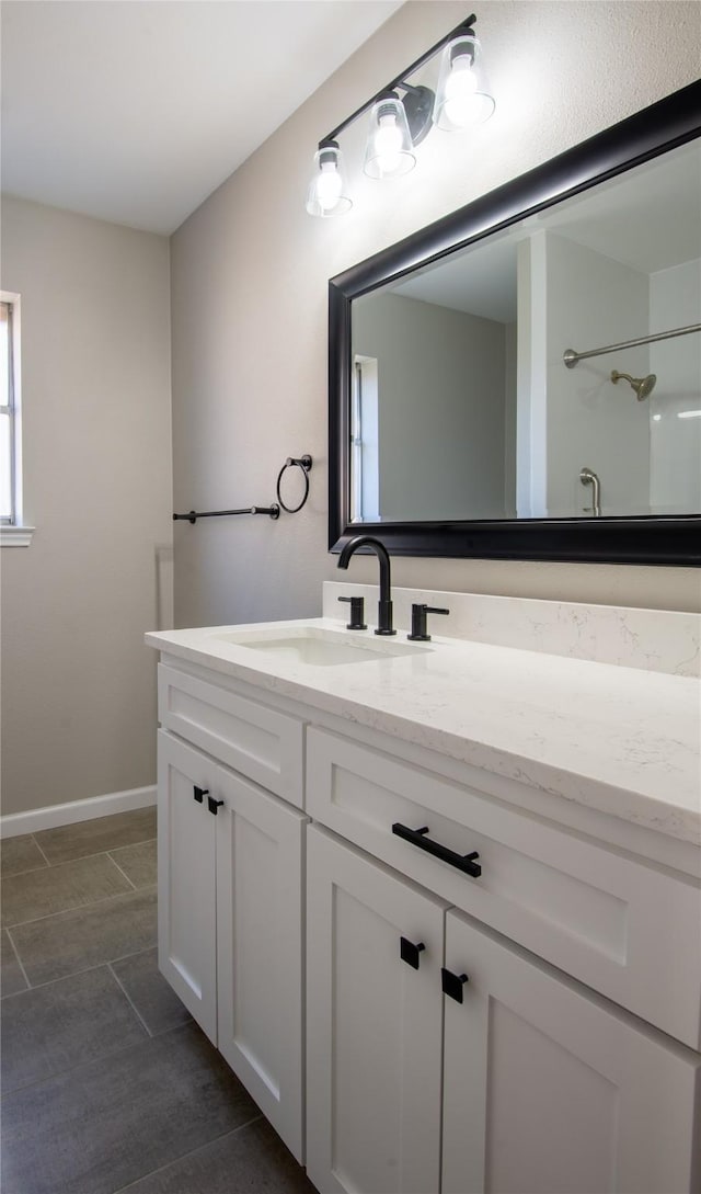 full bath featuring baseboards and vanity