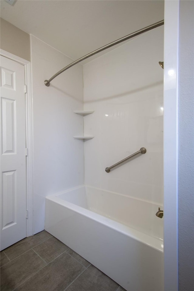 full bathroom with washtub / shower combination and tile patterned flooring