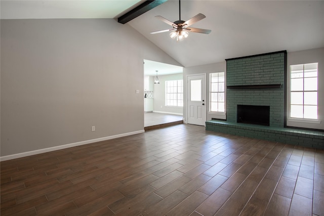 unfurnished living room featuring baseboards, a ceiling fan, dark wood-style flooring, beamed ceiling, and a brick fireplace