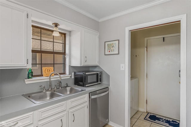 kitchen with light countertops, appliances with stainless steel finishes, a sink, and white cabinets