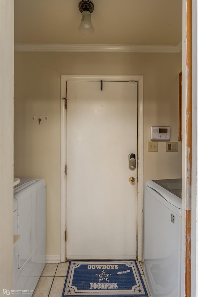 washroom featuring light tile patterned floors, laundry area, ornamental molding, and washer and dryer