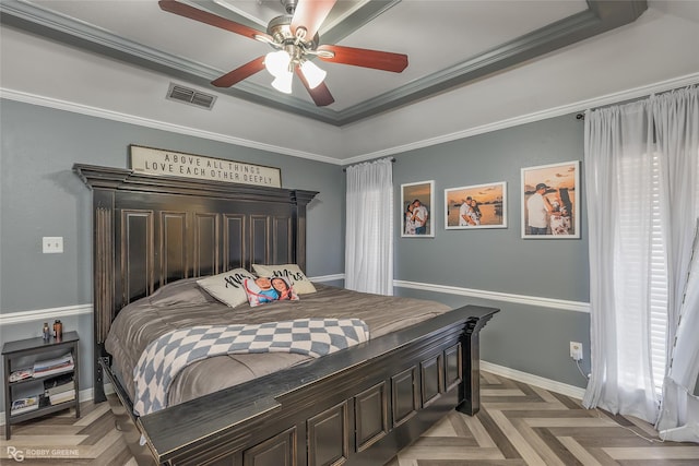 bedroom featuring visible vents, baseboards, a ceiling fan, ornamental molding, and a raised ceiling