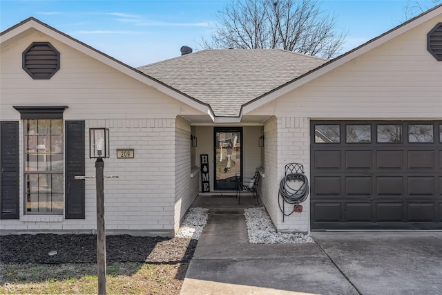 exterior space with a garage, concrete driveway, brick siding, and a shingled roof