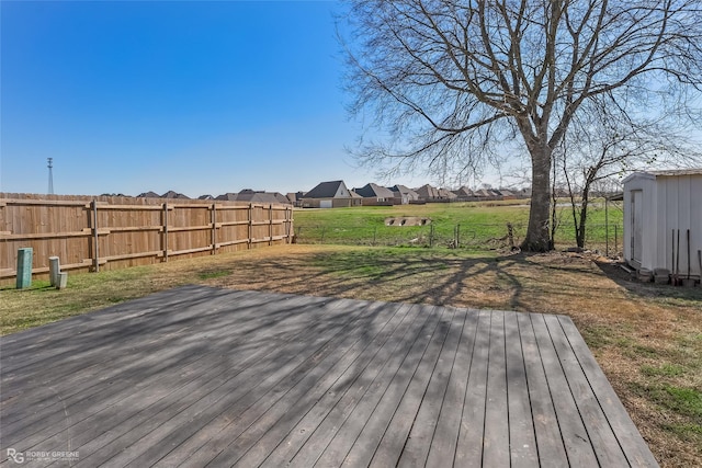 wooden terrace featuring a residential view, fence, and a lawn