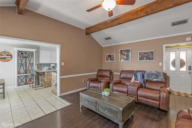 living room with vaulted ceiling with beams, baseboards, visible vents, and wood finished floors