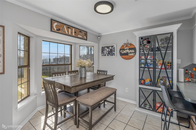 dining room featuring light tile patterned floors, ornamental molding, and baseboards