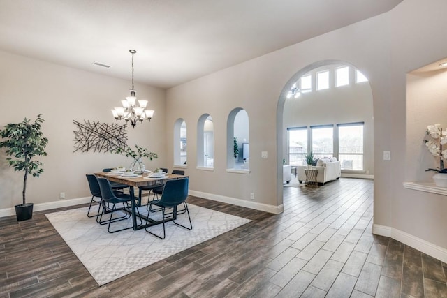 dining room featuring an inviting chandelier, wood tiled floor, visible vents, and baseboards