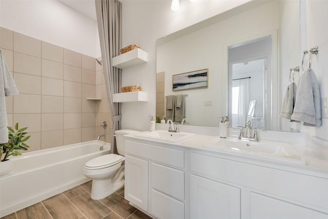 bathroom with toilet, wood tiled floor, double vanity, and a sink