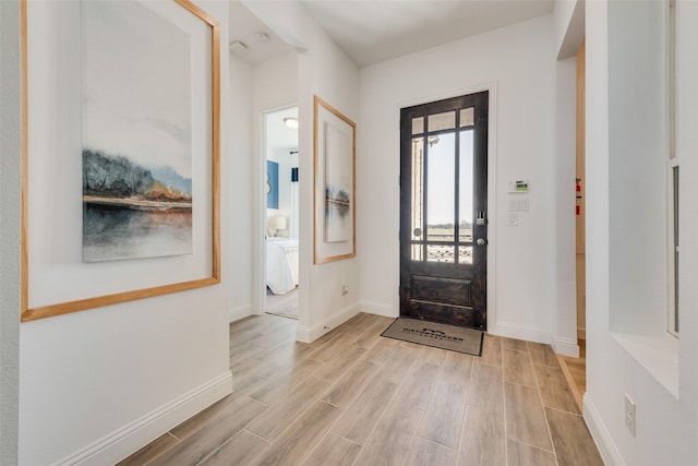 foyer featuring light wood-style floors and baseboards