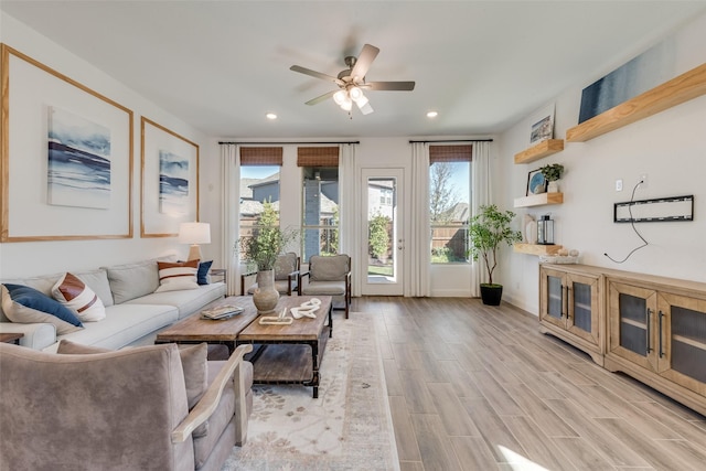 living area with recessed lighting, ceiling fan, and light wood-style flooring